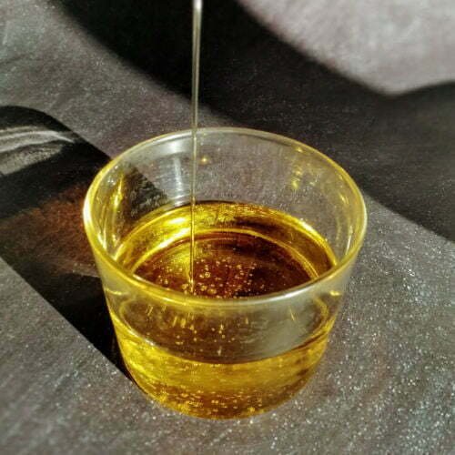 Olive oil is poured into a small clear glass