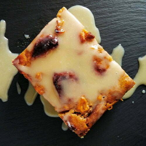 Pumpkin bread pudding with a gooey caramel sauce sits on a slate plate