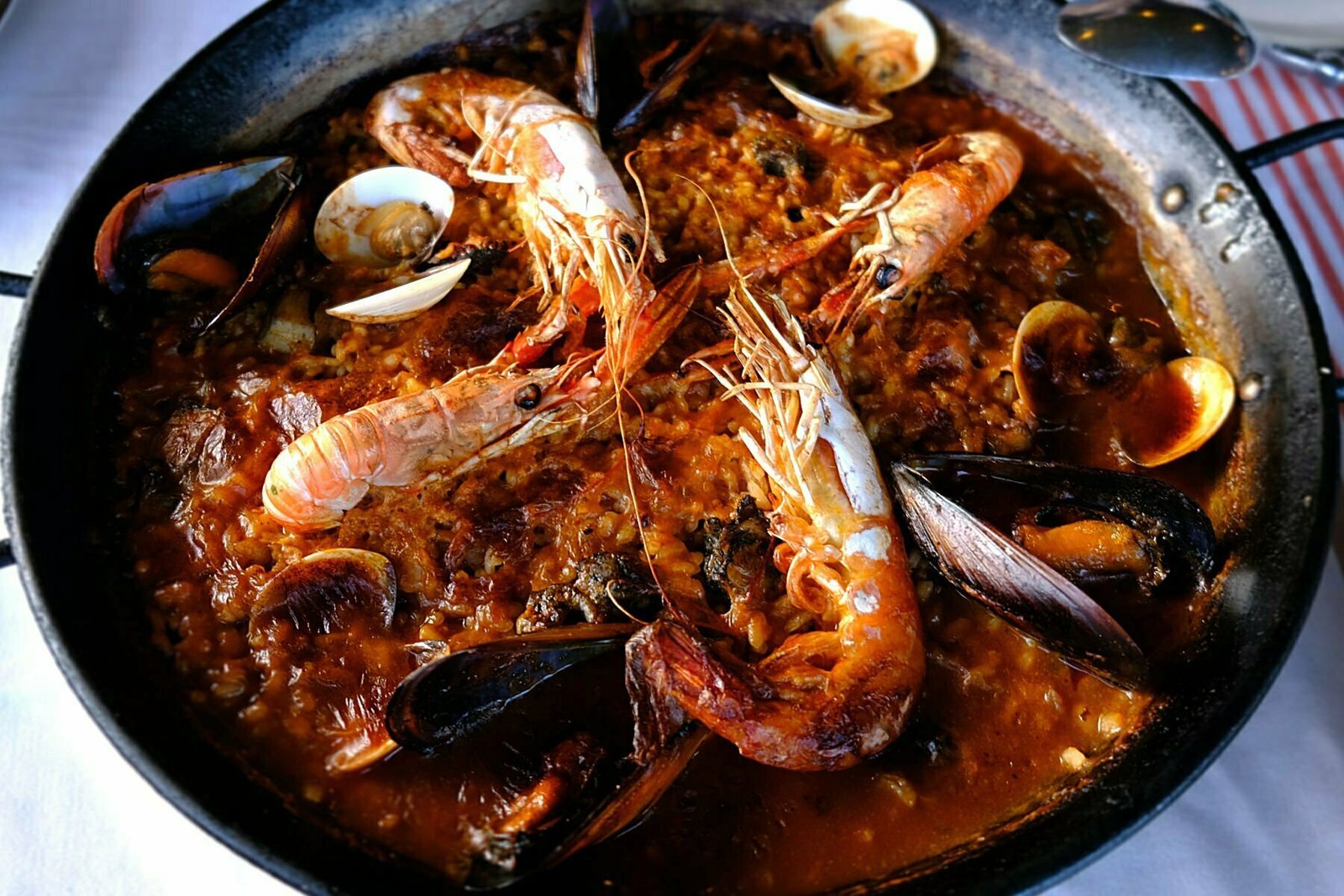 A large seafood paella sits on a table