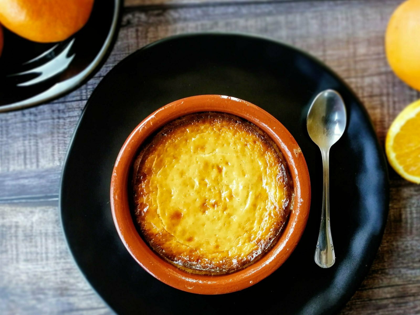 a plate of baked cheesecake with hoey and orange ists on a wooden countertop