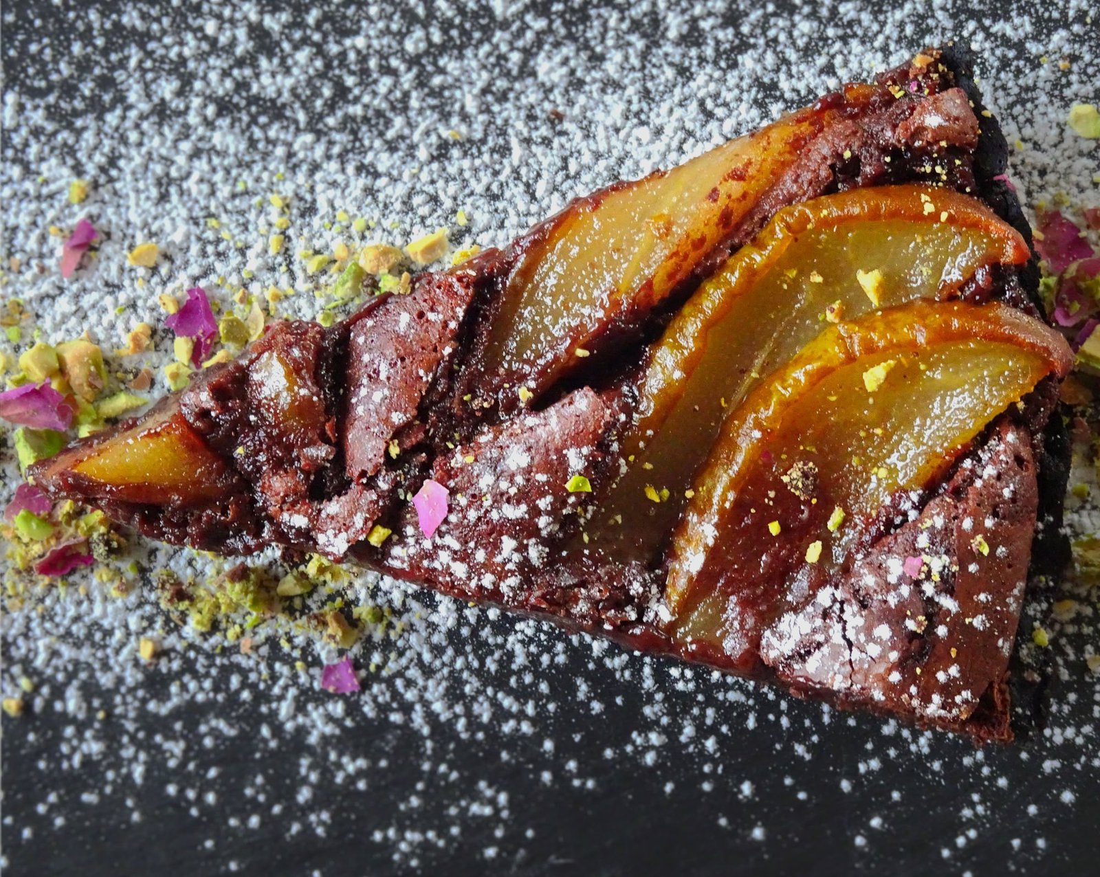 Chocolate and pear tart infused in Sweet Spanish Sherry slice sits on a slate plate