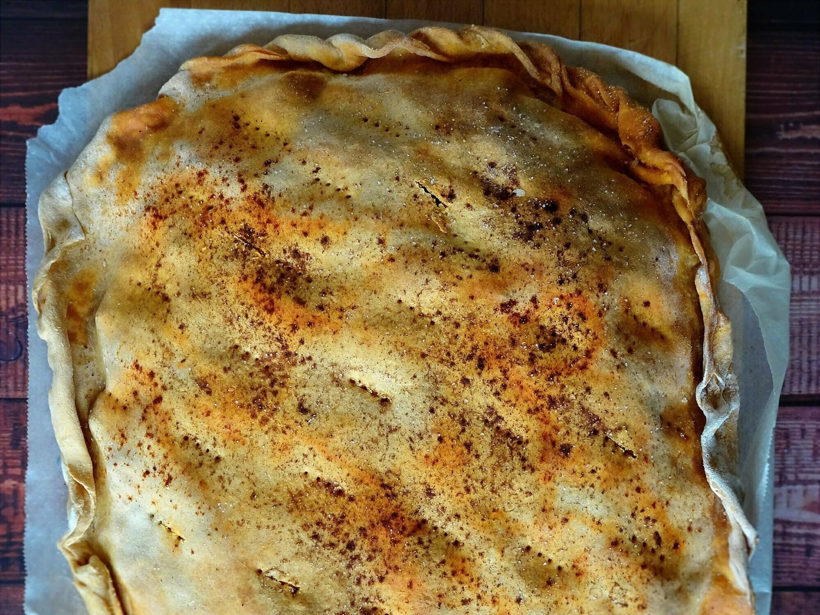 empanada-gallega-half-2000x1500 a golden empanada gallega sits on parchment paper aiting to be served