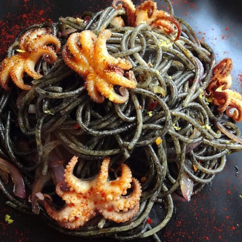 A plate of Squid ink pasta with baby squid