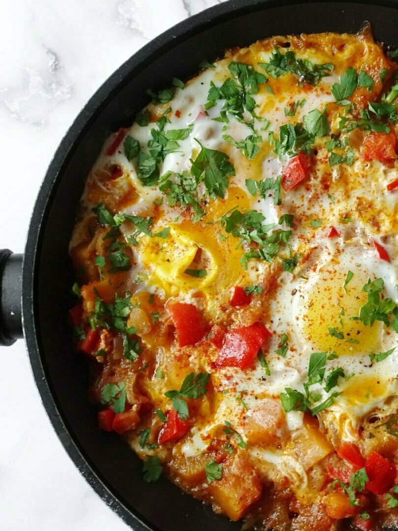 a frying pan sits with Pisto Murciano, a colorful arrangement of fried vegetables and egg