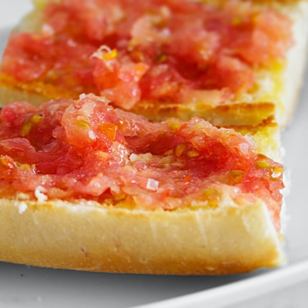 a small plate holds two slices of pan con tomate