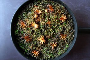 a large pan of squid ink pasta sits on a dark countertop