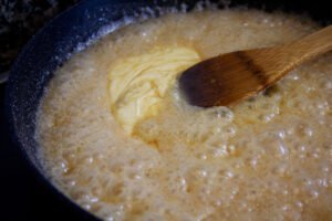 doubble cream is added to salted caramel mixture in a frying pan