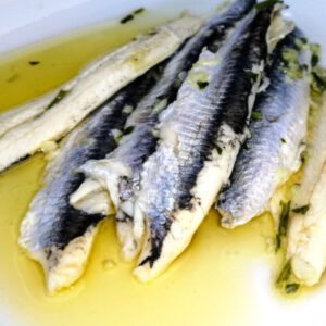 A plate of boquerones spanish anchovies marinaded in vinegar garlic and parsley and drizzled with extra virgin olive oil