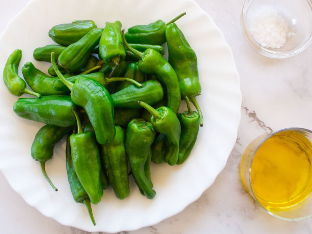 ingrednients for padron peppers sits on a white granite counter