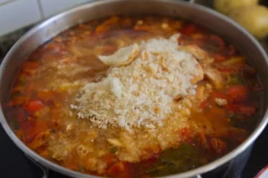 some breadcrumbbs are added to a pan of chickpea stew