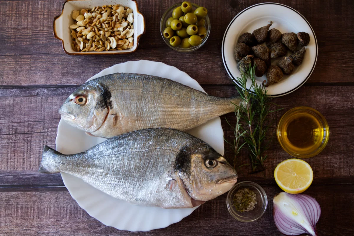 ingredients for roasting whole fish are laid out on a table.<br />
 