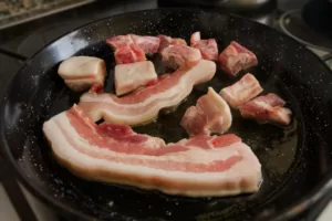 some strips of pancetta cook in a pan