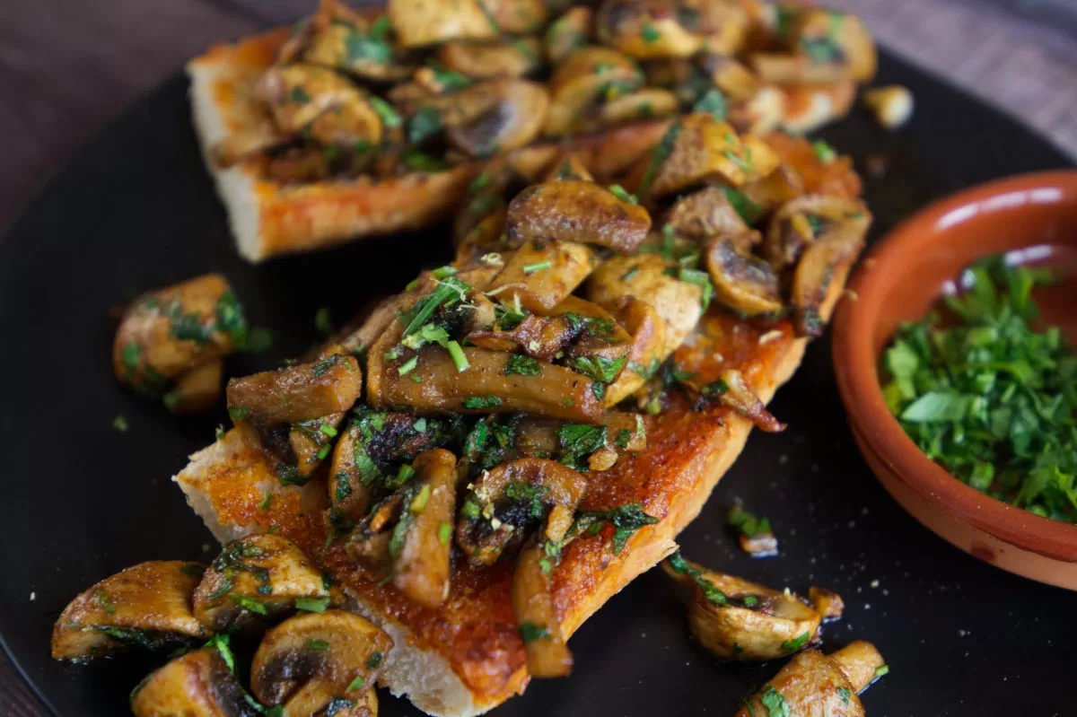 A plate of Spanish garlic mushrooms on some fried bread