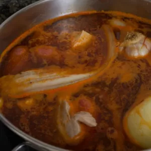 meat paprika and saffron are added to a simmering pot of fabada asturiana