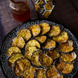 slices of berenjena con miel sit on a crystal plate