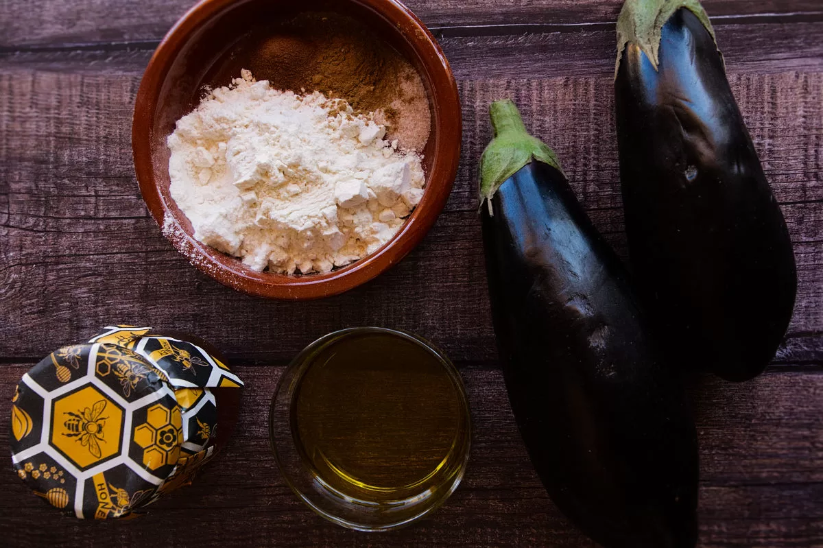 ingredients used to make berenjena con miel are laid out on a wodden table