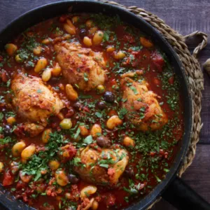 a pan of chicken thighs with chorizo and wine