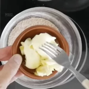 Some butter is added to a bowl with sugar, flour, and cinnamon.