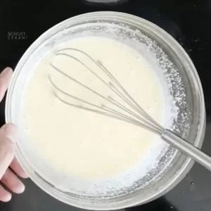 Eggs and sugar are whisked in a glass bowl