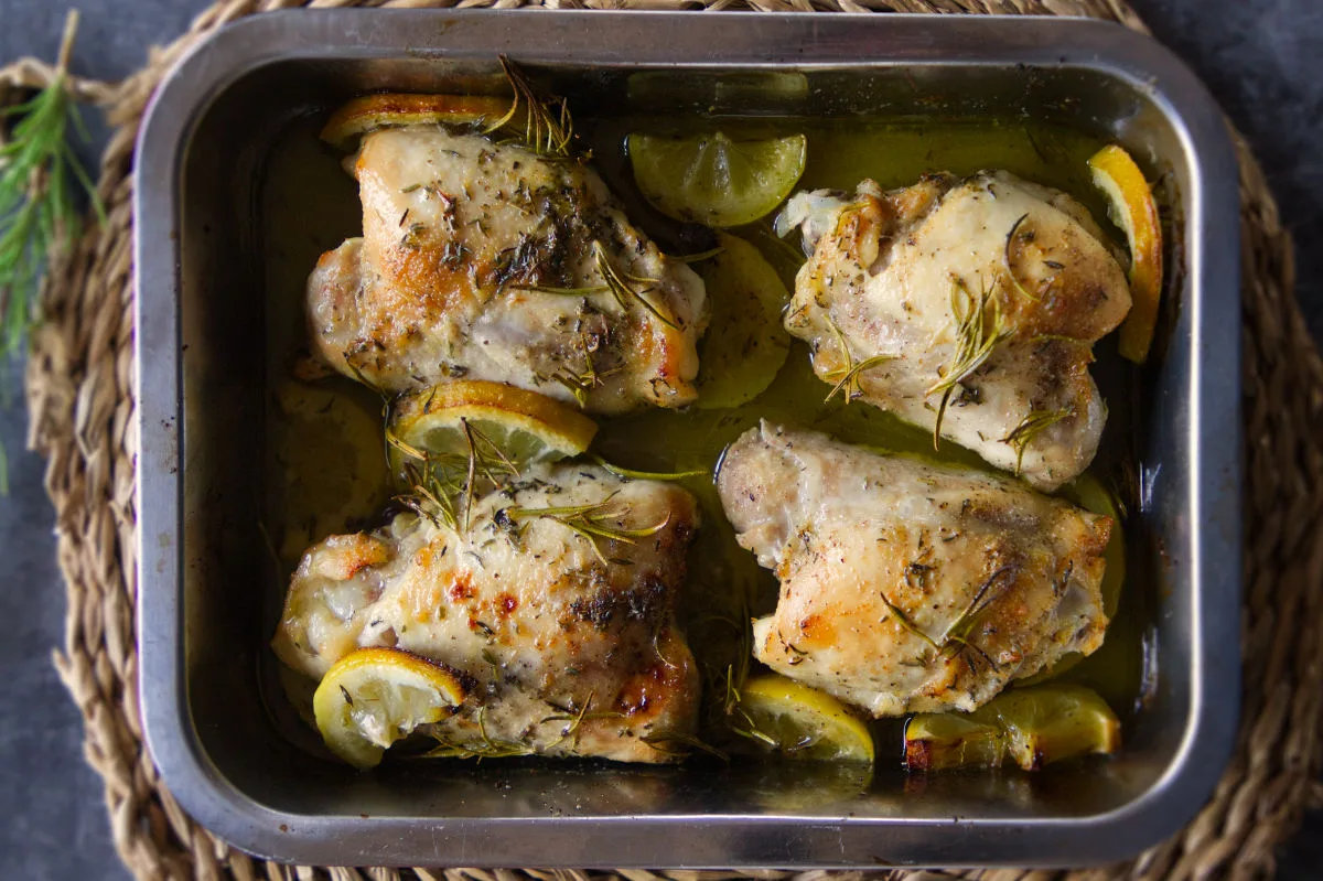 A baking tray of lemon and herb chicken thighs. 