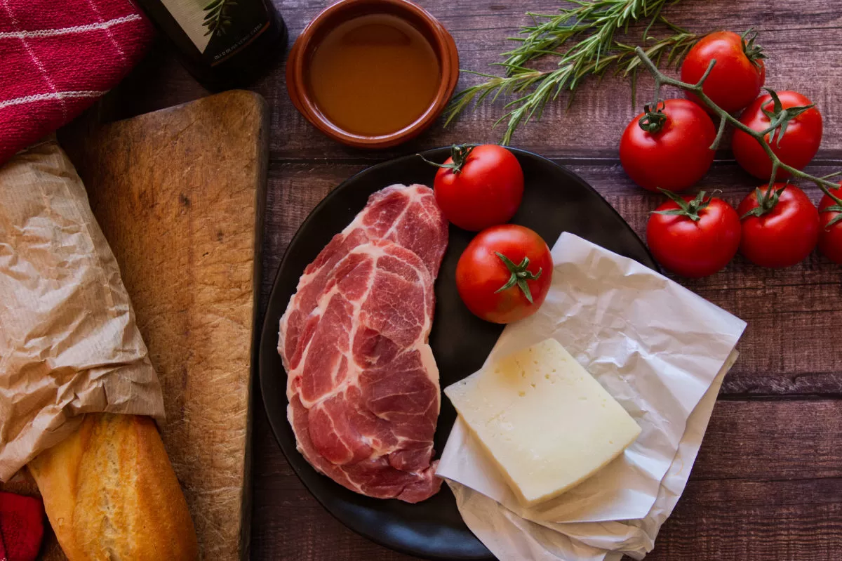 ingredients for making a pork loin sandwich are laid out on a kitchen table. 