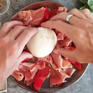 A ball of Burrata cheese is placed on a plate.