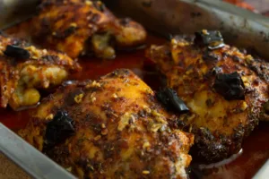 A tray of oven-baked spicy Mediterranean chicken thighs.