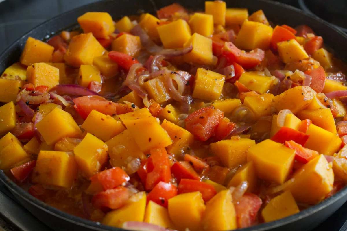 Pieces of pumpkin cook in a pan. 