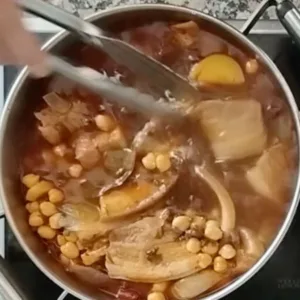 Stew simmers down with lots of pork pieces and morcilla.