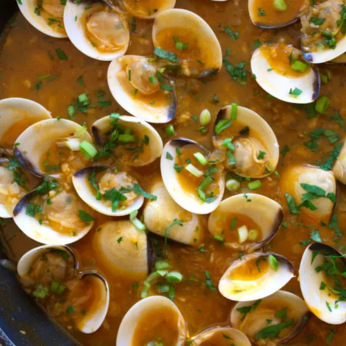 A large pan of Spanish-style clams in tomato and wine.