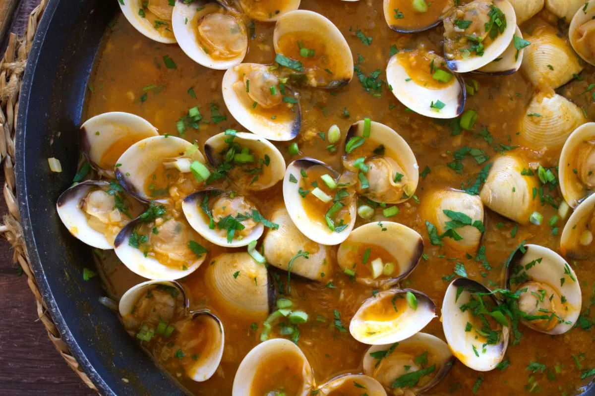 A large pan of Spanish-style clams in tomato and wine.