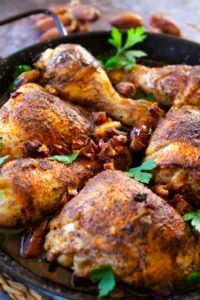 Mediterranean-style crispy chicken pieces in a deep pan with some fresh parsley.