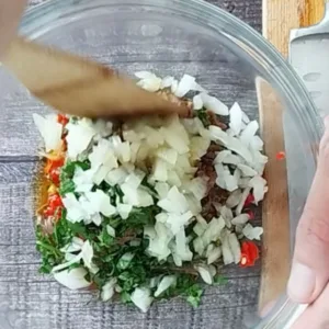 Chopped ingredients sit in a bowl.