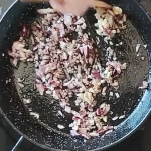 Onion cooks in a pan with some oil.