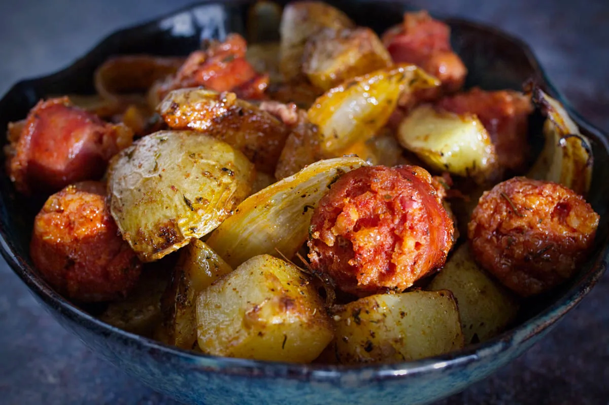 A bowl of roasted potatoes with chorizo and thyme