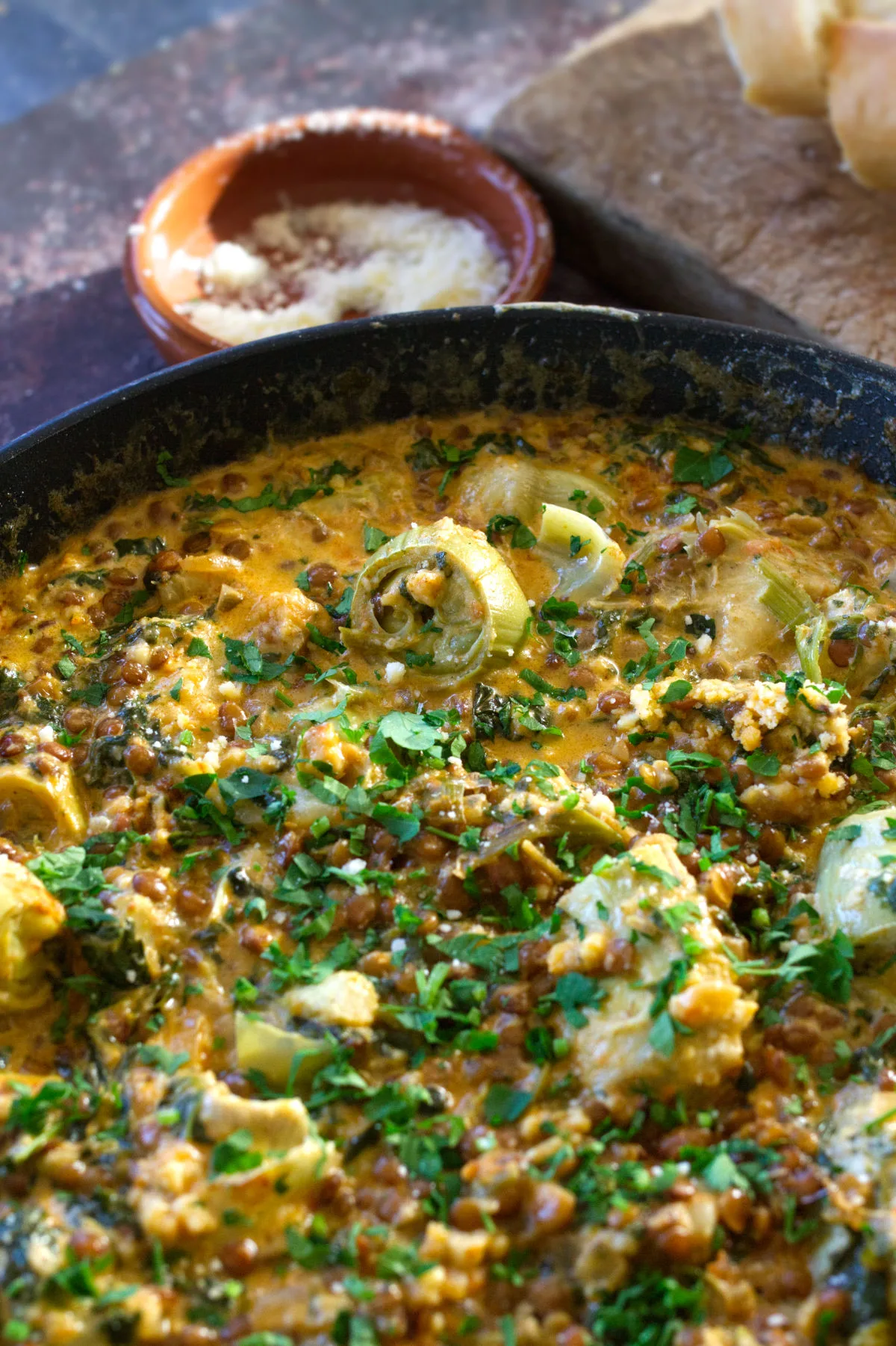 A pan of creamy artichoke casserole with spinach and paprika.