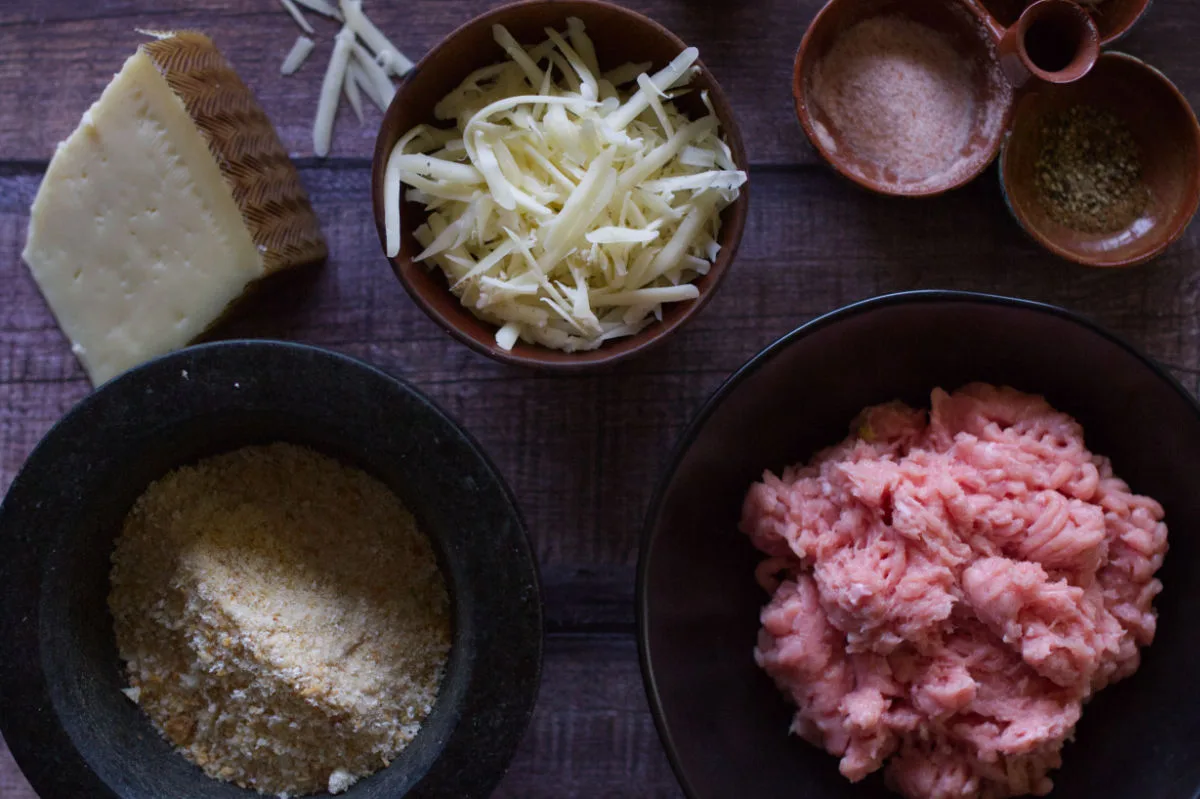 ingredienst to make chicken meatballs are set out on a kitchen table.