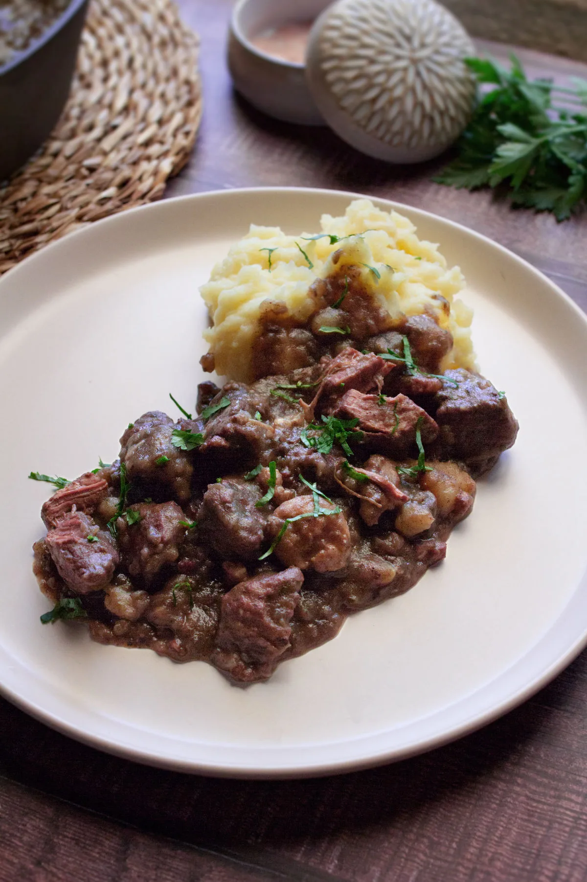 A plate of Catalan style beef stew with some mashed potato.