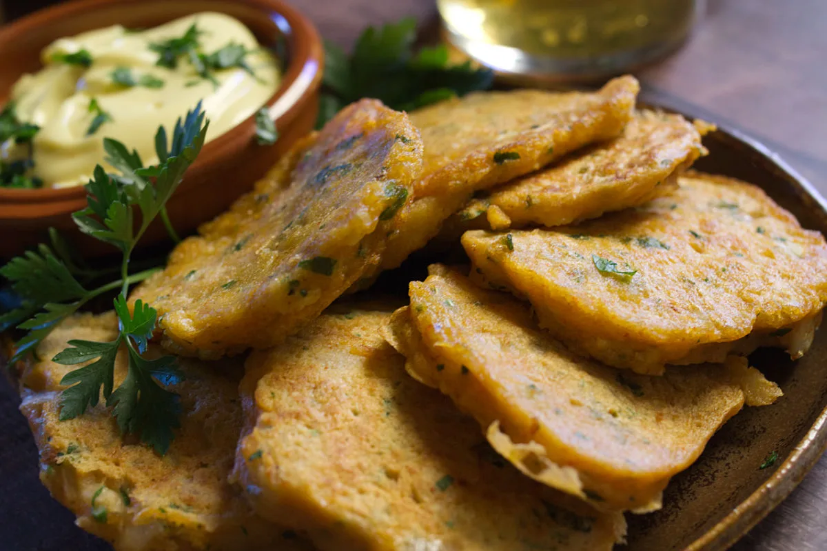 A tapas serving of Spanish cod fritters sits beside some homemade aioli.