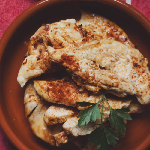 a small bowl of cooked chicken breast with garlic and paprika