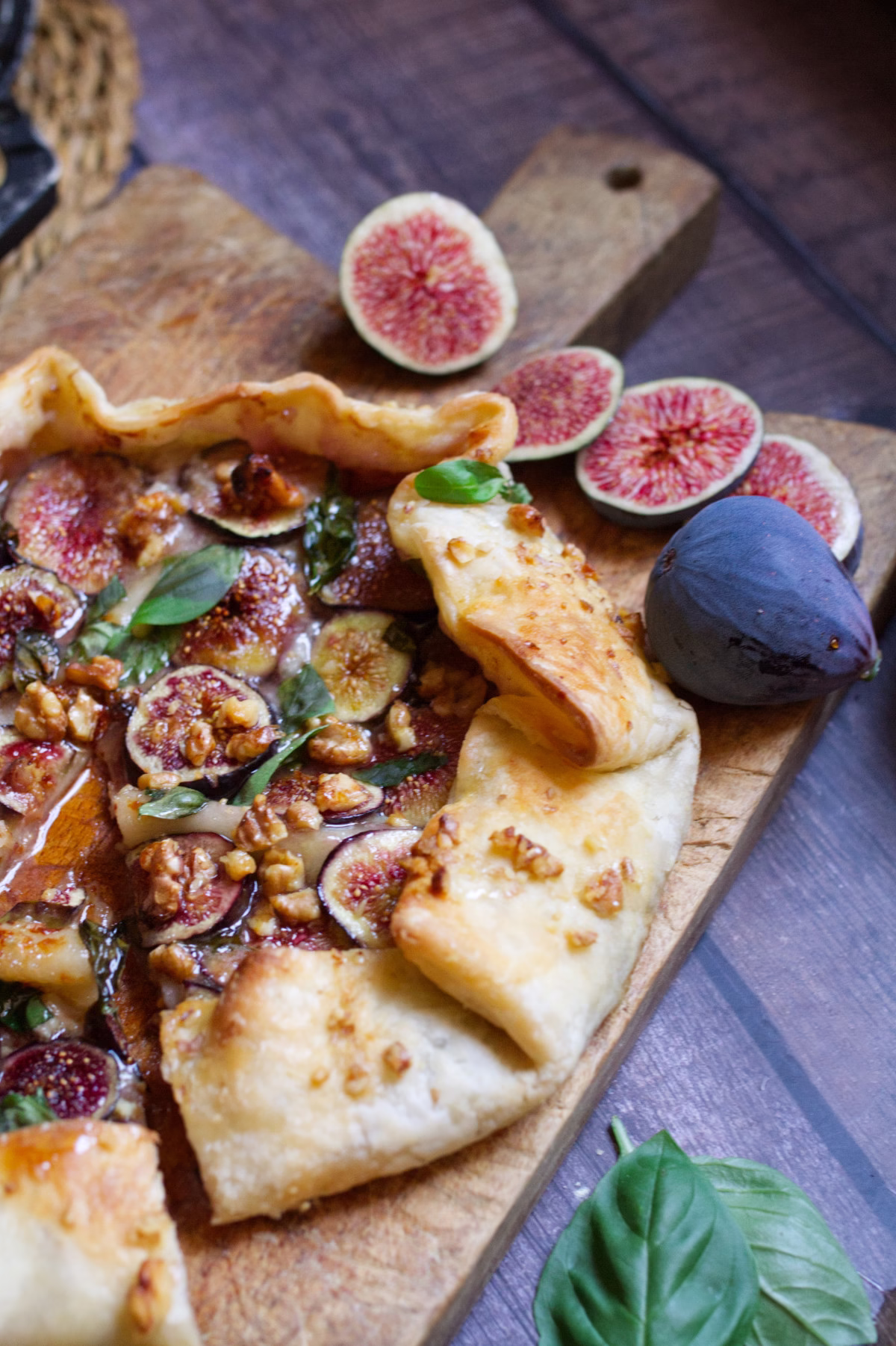A baked gorgonzola fig and walnut tart is sliced on a cutting board