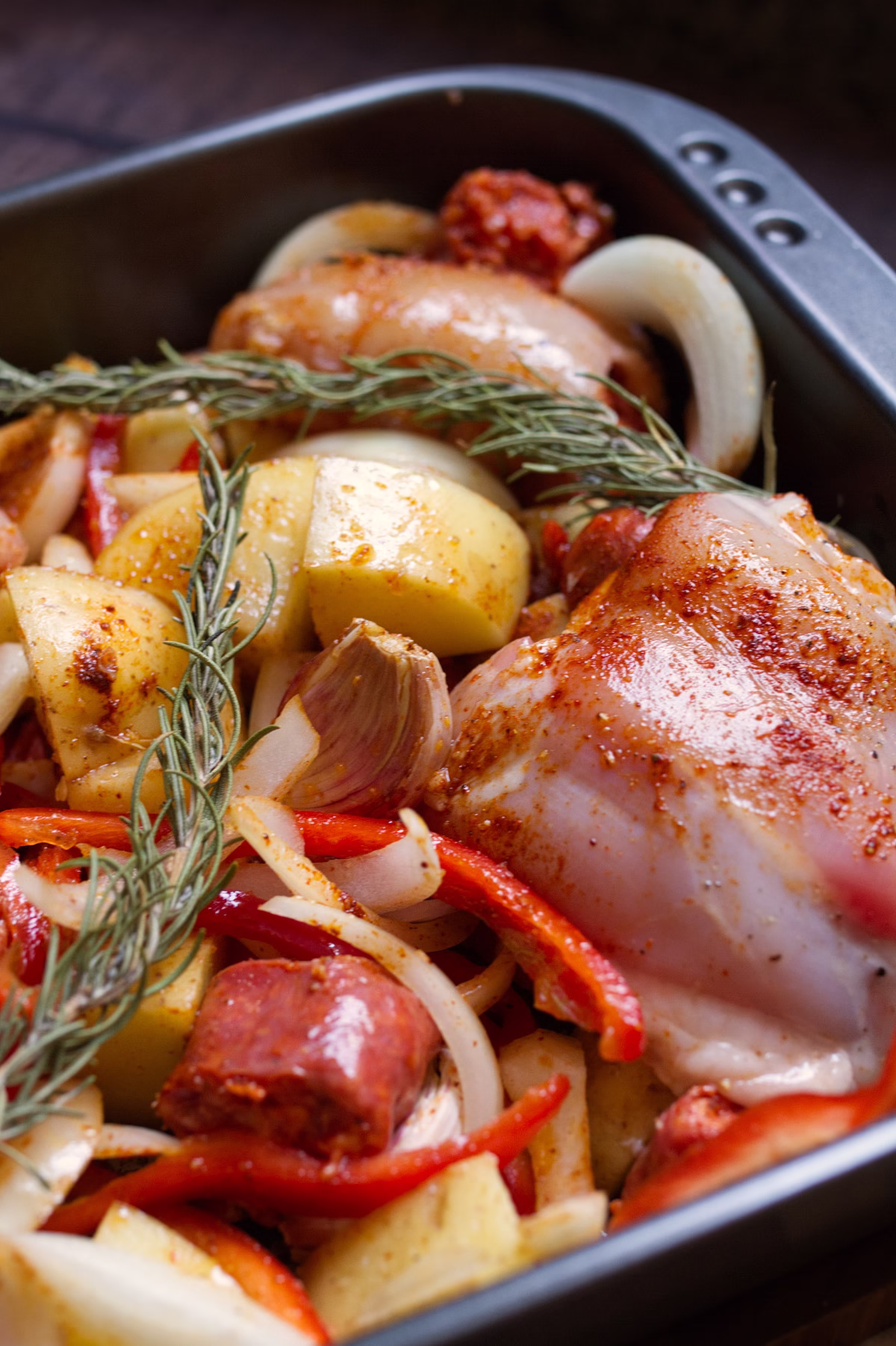 A pan of uncooked Chicken with chorizo and potatoes