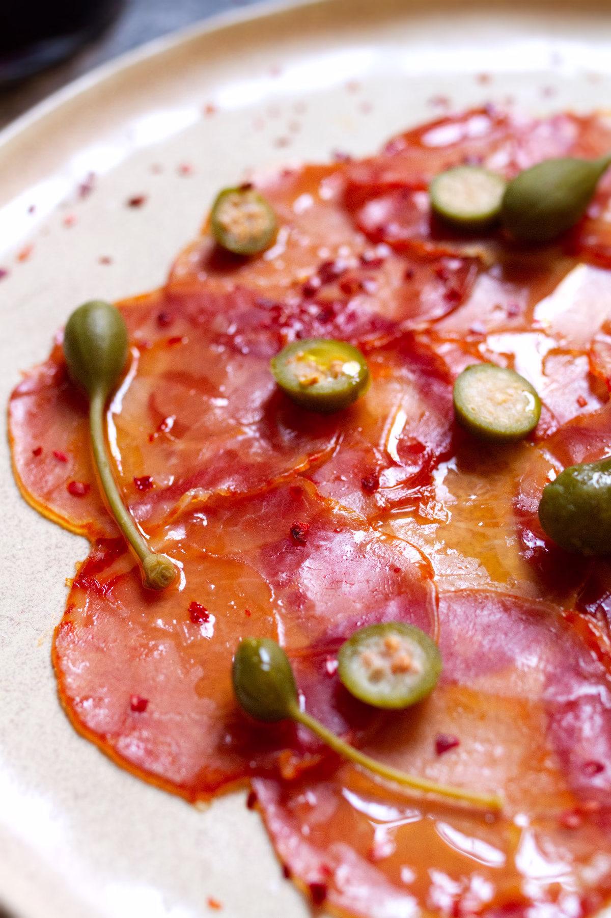 Lomo Iberico with Alcaparras and Nora Pepper-v2 a plate of Lomo Ibérico with Alcaparras & Ñora Pepper
