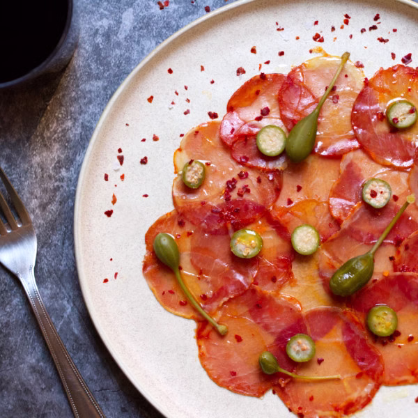 a plate of Lomo Ibérico with Alcaparras & Ñora Pepper