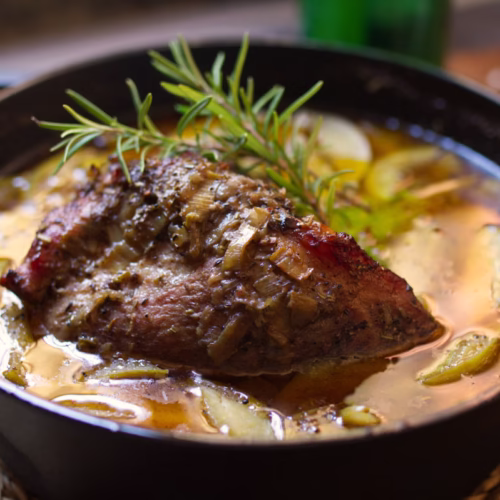 A dutch oven with some braised pork and Asturian cider
