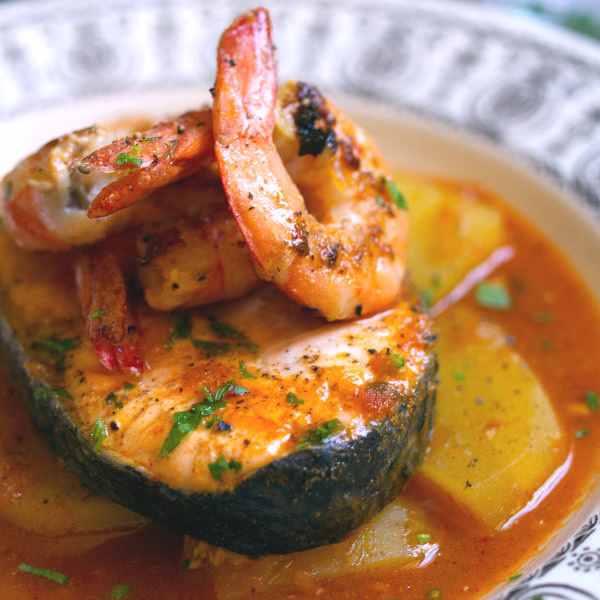 A serving of Spanish salmon stew with a shrimp on top