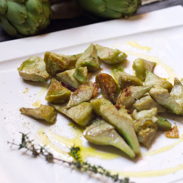 A plate of pan-fried artichoke with garlic and lemon
