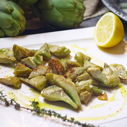 A plate of pan-fried artichoke with garlic and lemon