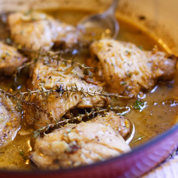 Spanish garlic lemon chicken in pan with garlic and herbs