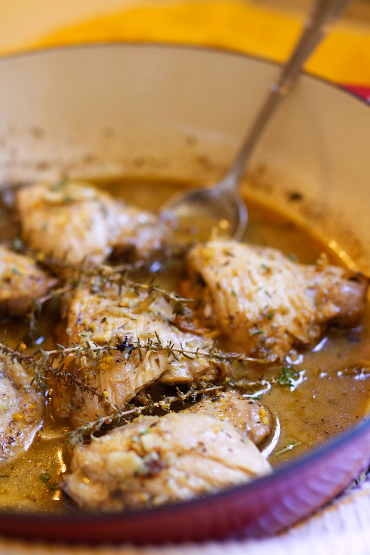 Spanish garlic lemon chicken in pan with garlic and herbs
